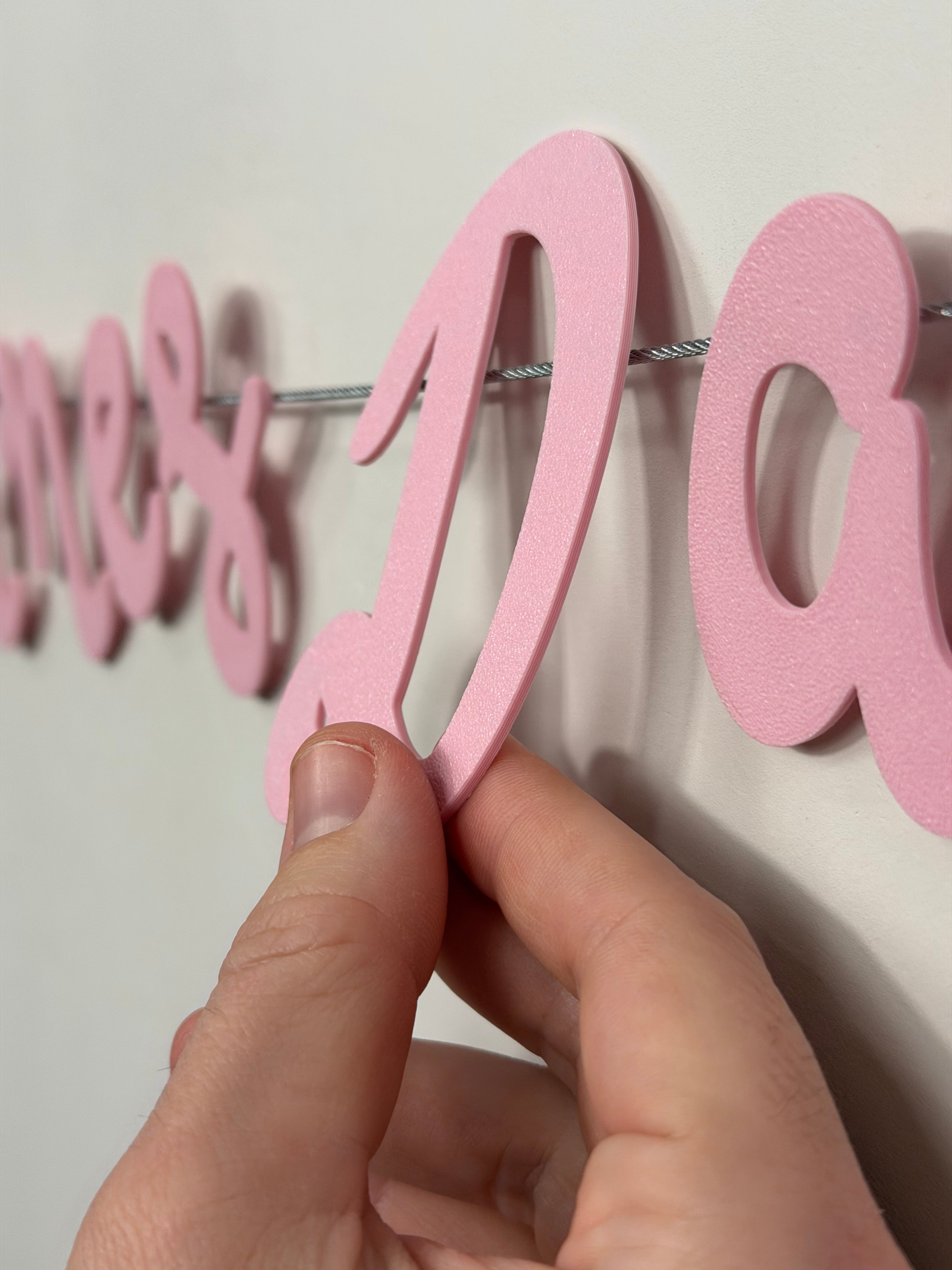 up close shot of a hand placing a pink letter on the snap banner